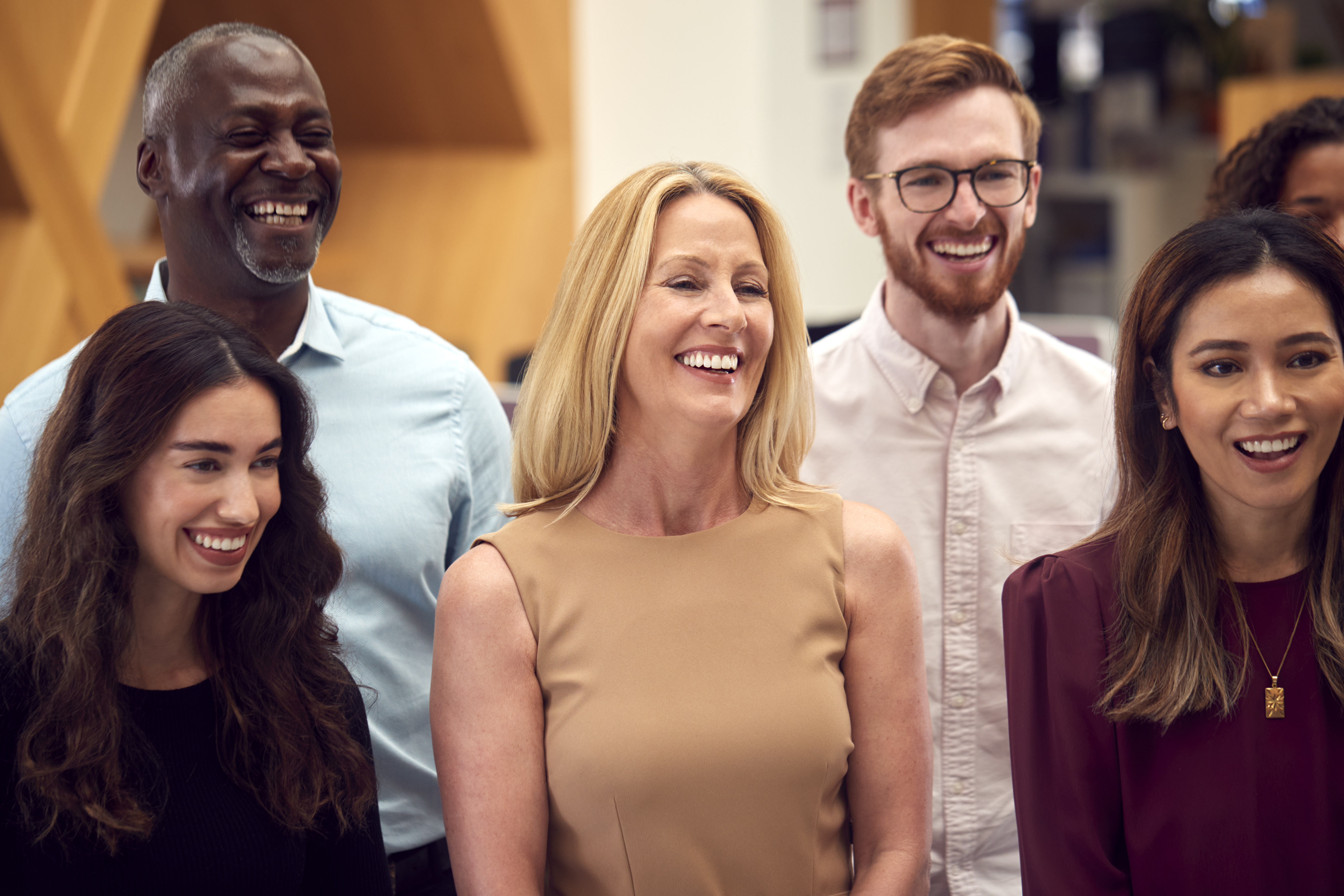 Portrait Of Smiling Multi-Cultural Business Team Standing In Modern Open Plan Office